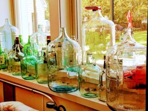 Empty bottles of various sizes sit in a window